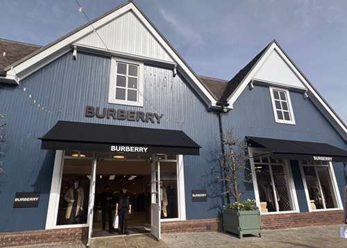Burberry storefront in blue facade at an outlet village.